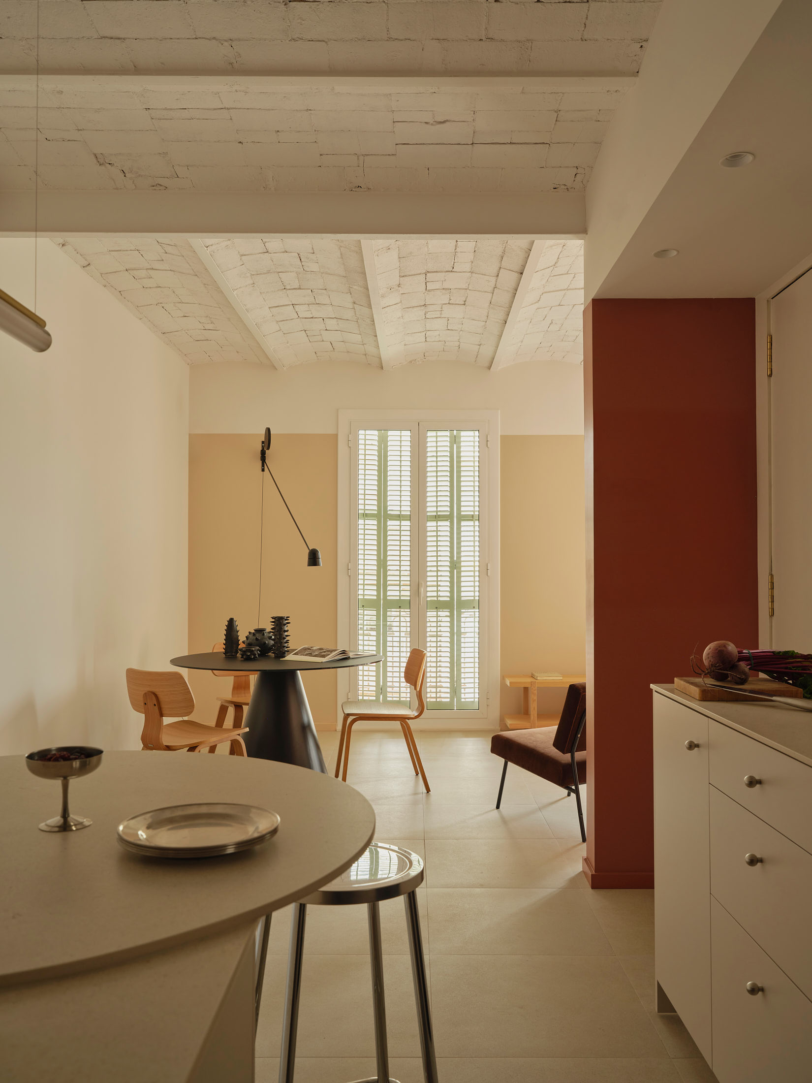 Viladomat Apartment in Barcelona by Colombo Architecture - living and dining area with round table and Catalan vaulted ceiling