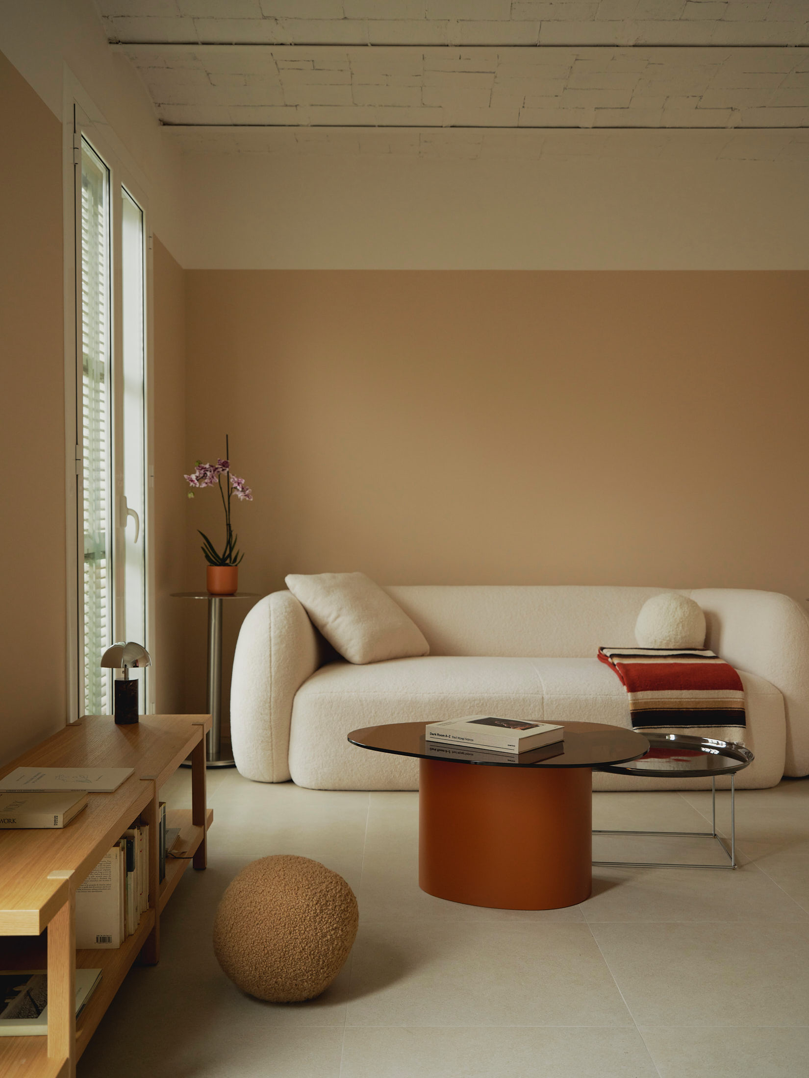 Viladomat Apartment in Barcelona by Colombo Architecture - living room with boucle sofa, terracotta table and wooden bookshelf