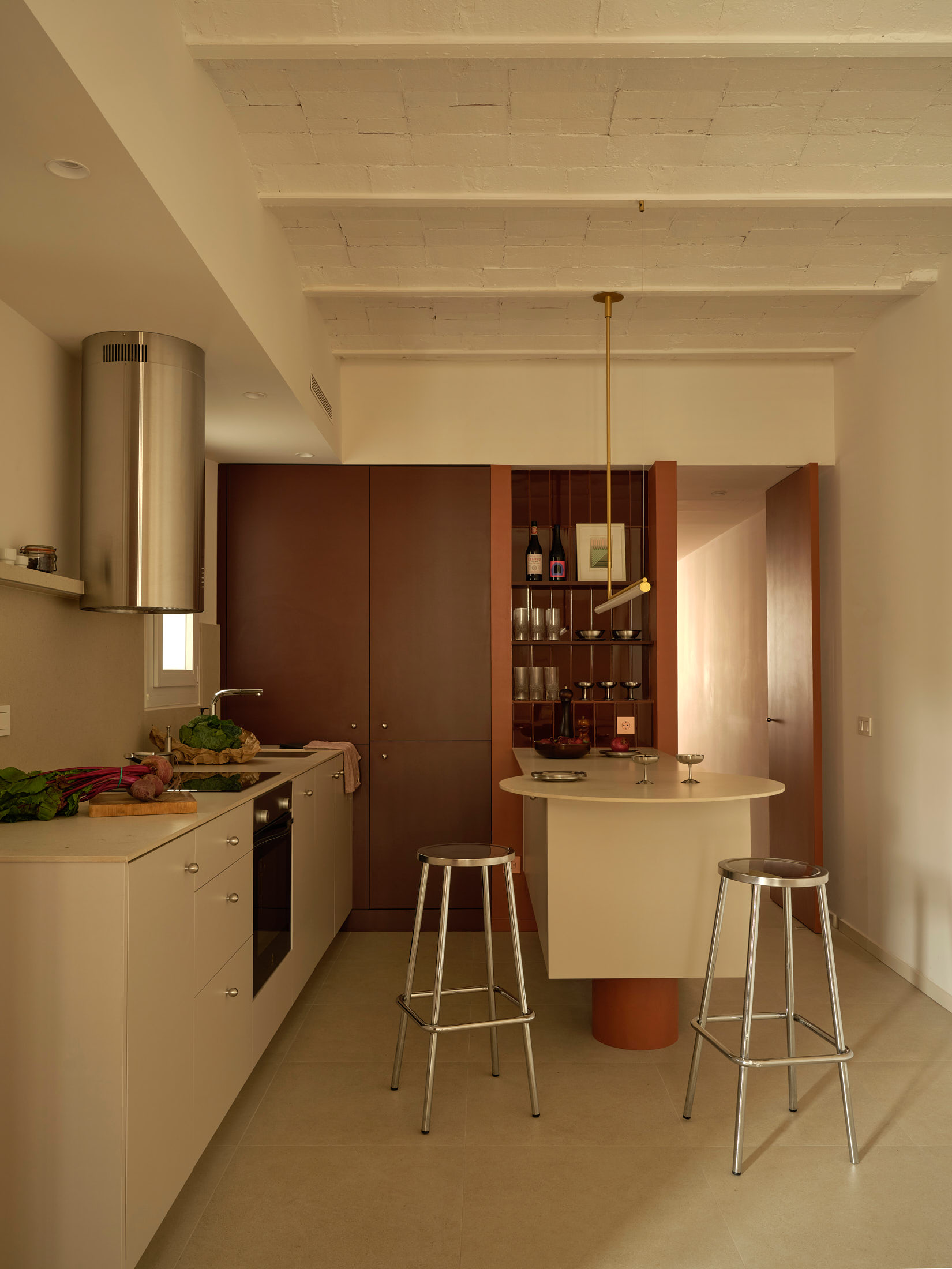 Viladomat Apartment in Barcelona by Colombo Architecture - kitchen with steel hood, red block and breakfast island