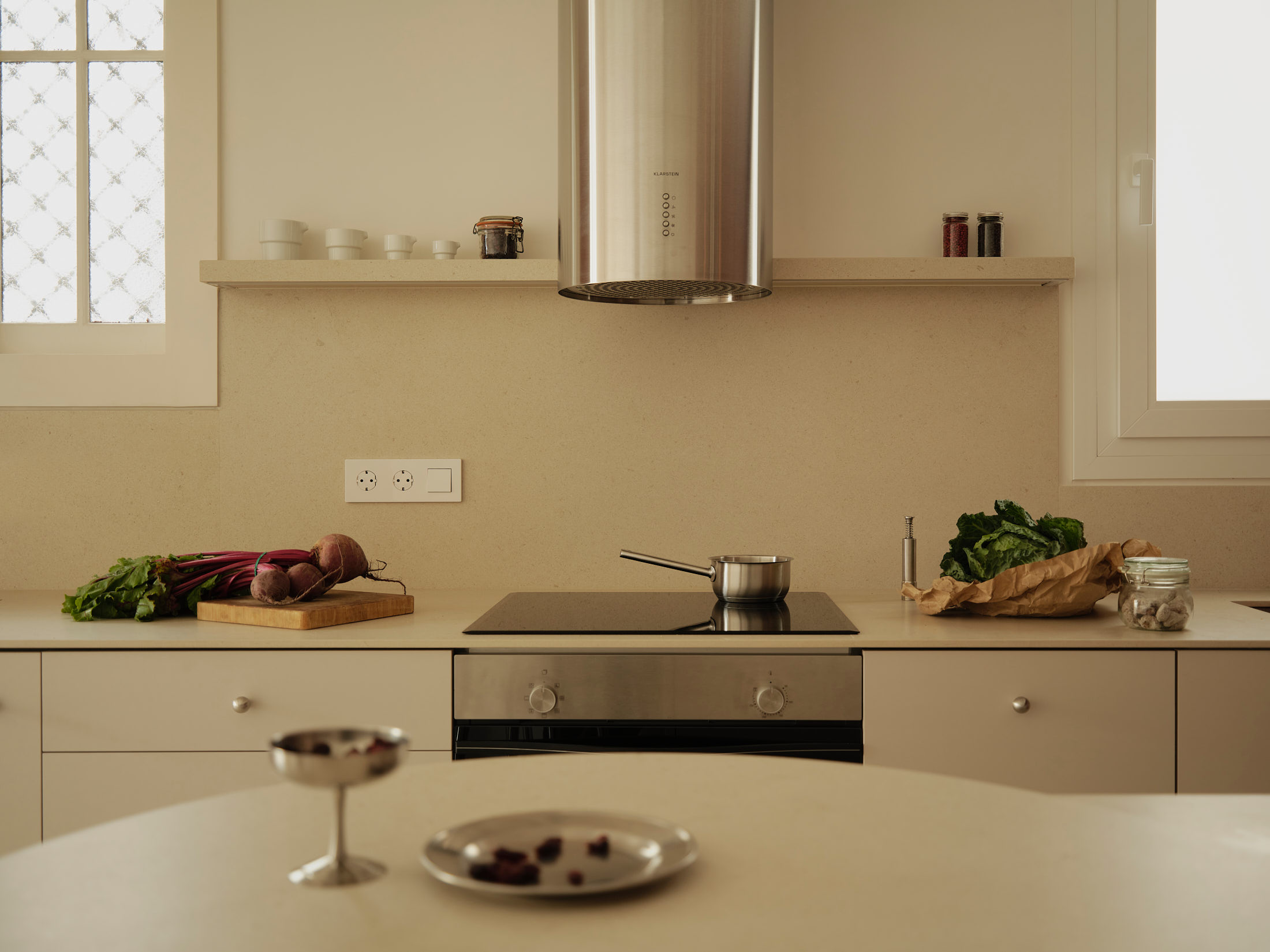 Viladomat Apartment in Barcelona by Colombo Architecture - kitchen worktop with induction hob and steel hood