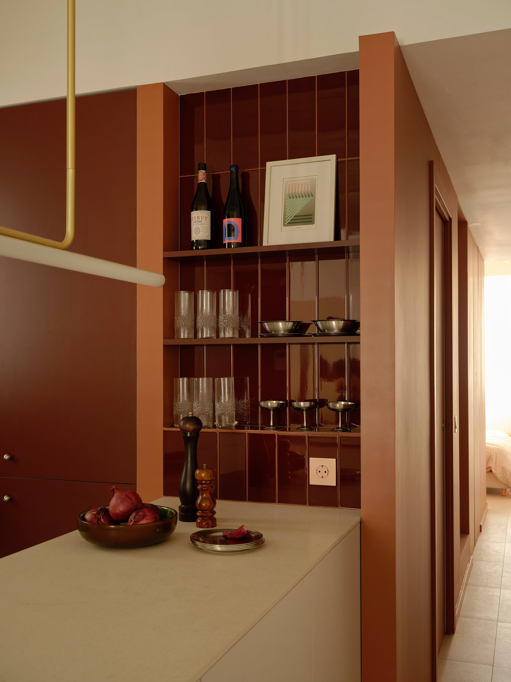 Viladomat Apartment in Barcelona by Colombo Architecture - detail of the glossy red tiled niche and bespoke shelving