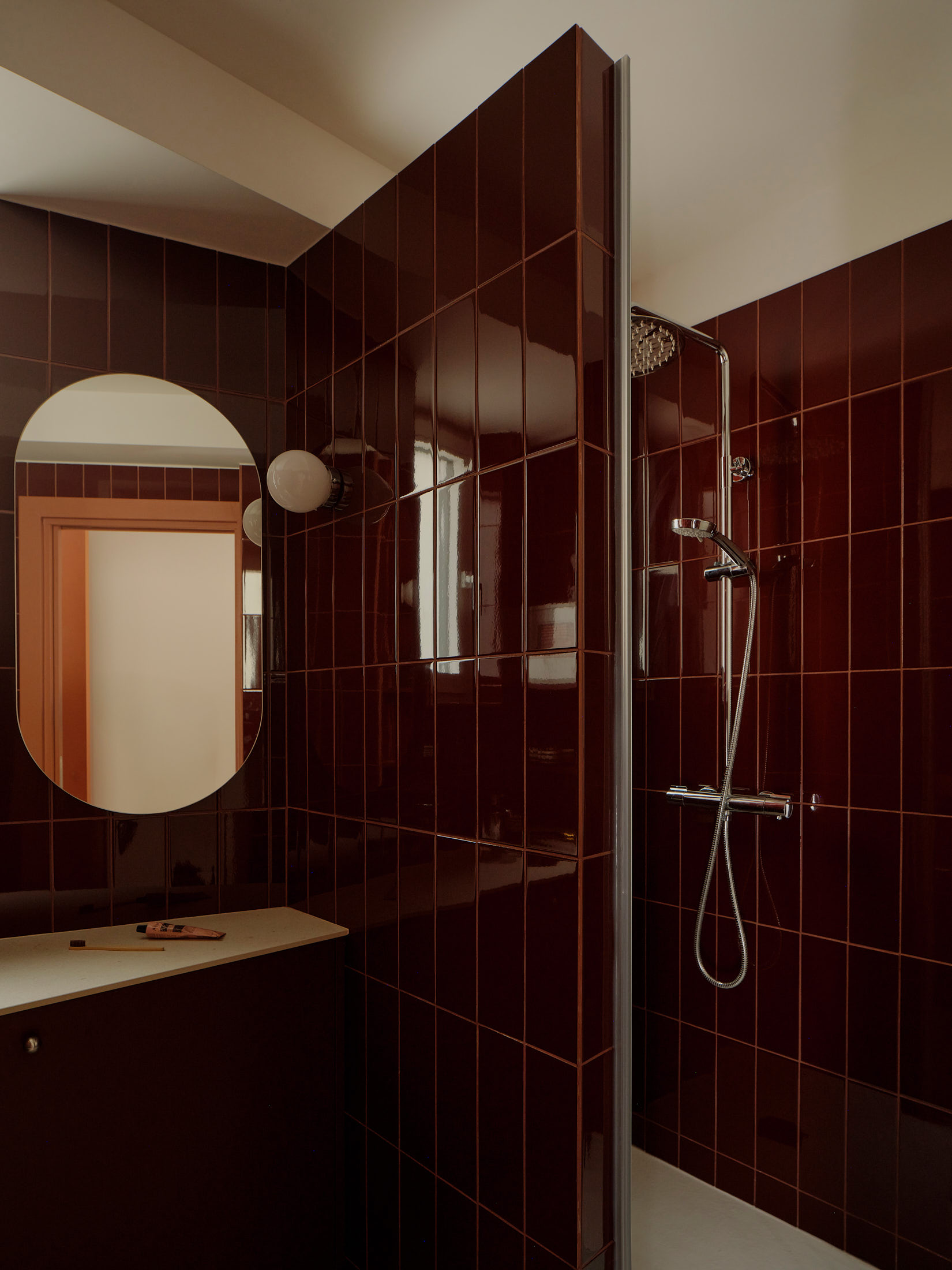 Viladomat Apartment in Barcelona by Colombo Architecture - bathroom with shower screen and round mirror