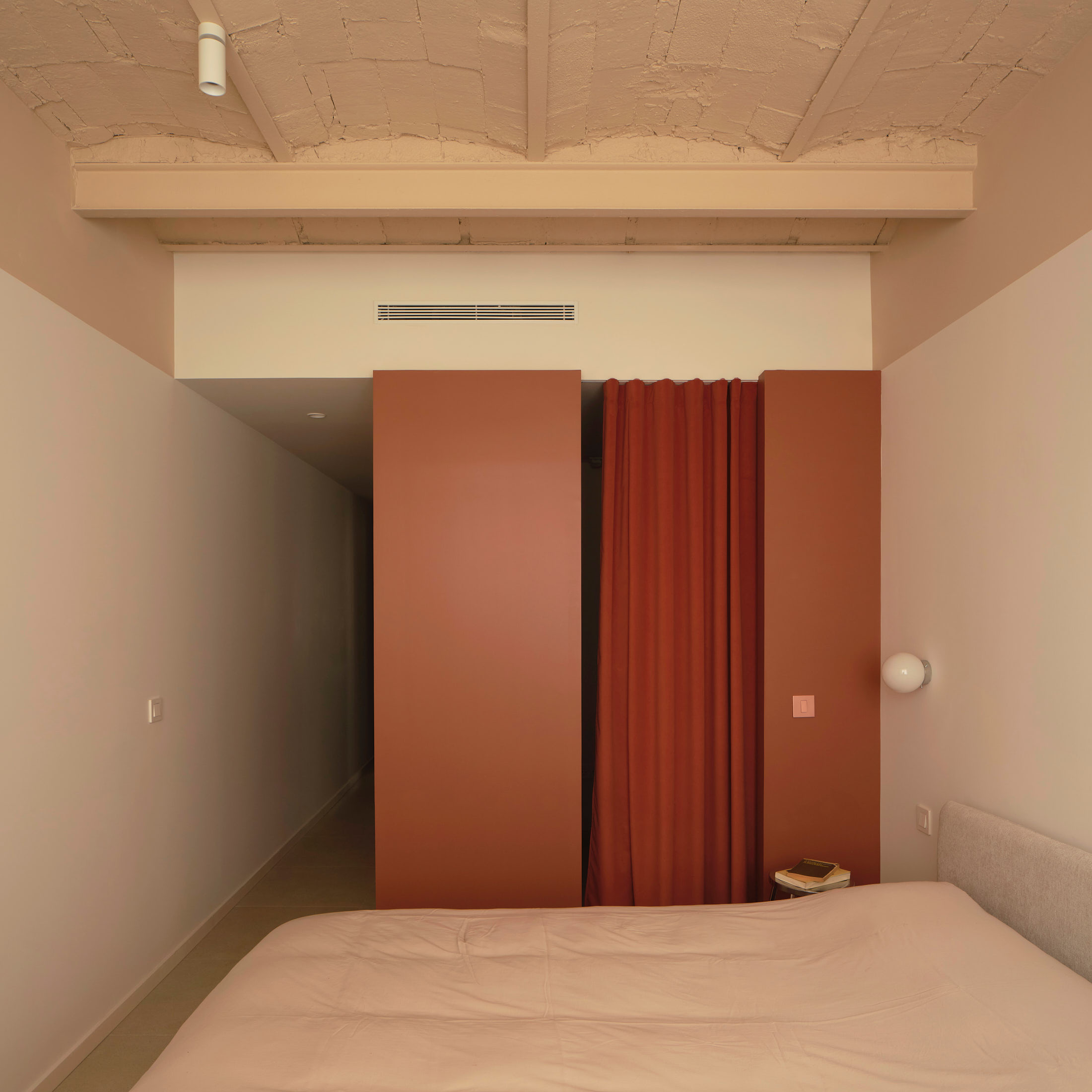 Viladomat Apartment in Barcelona by Colombo Architecture - bedroom with clay red volume and curtain